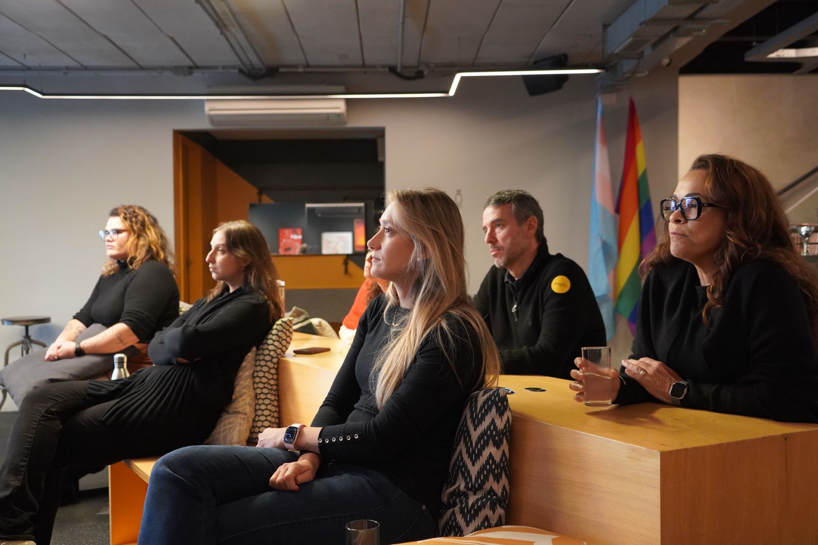 Participantes acompanham atentamente uma apresentação de cultura organizacional em um ambiente colaborativo de trabalho.